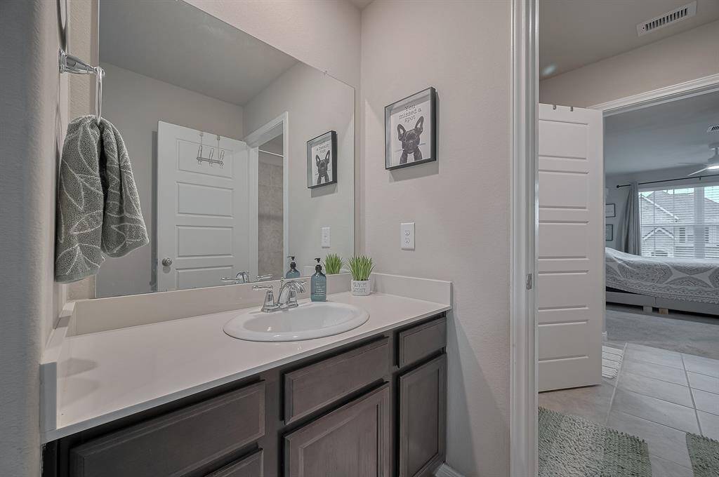 The Jack and Jill  connects to a bright bedroom with ample natural light and contemporary decor.