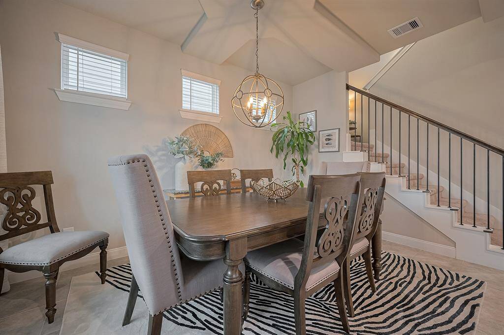The staircase with wrought iron railing adds charm, and natural light streams through the windows, creating a welcoming atmosphere.