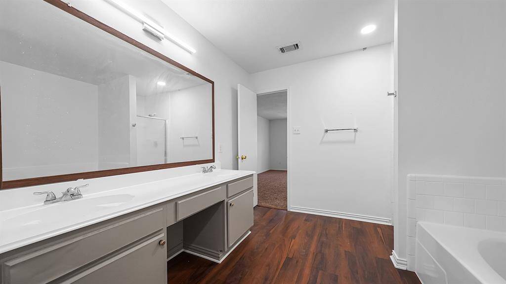 Gorgeous primary ensuite feautres dual sinks, makeup vanity, frames mirror and soaking tub!