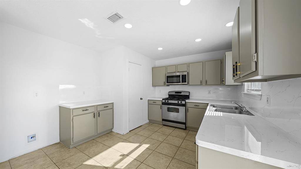 Experience culinary bliss in this spacious kitchen, featuring abundant counter and cabinet space, complemented by sleek stainless steel appliances.