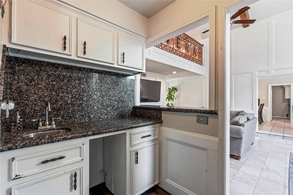 Tucked just off the main living area, this granite-topped wet bar is the perfect setup for entertaining, serving drinks, or creating a coffee nook with personality.