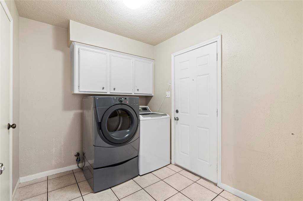 Spacious laundry room with overhead storage and easy access to the garage—functional and tucked away for everyday convenience.