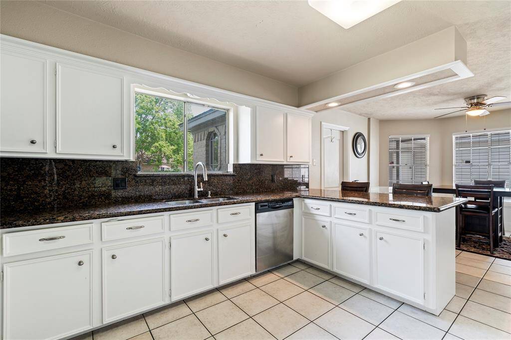Spacious and functional, this kitchen features generous counter space, bright white cabinetry, and a view to the front yard from the sink—keeping the space open and connected.