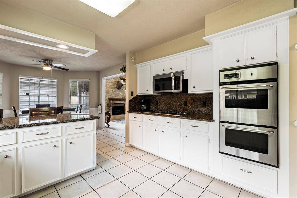 The kitchen features double ovens, a gas cooktop, and ample storage—designed to handle everything from weeknight dinners to weekend gatherings with ease.