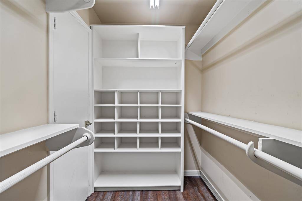 The walk-in closet offers built-in shelving, dedicated shoe storage, and plenty of hanging space to keep everything organized.
