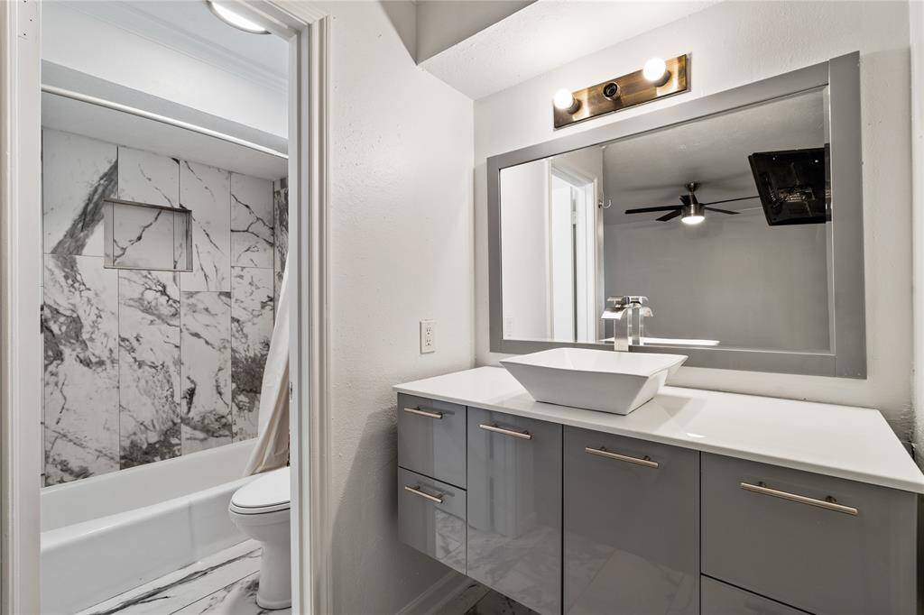 Upstairs secondary suite with a private en-suite bathroom featuring a modern vanity and shower-tub combo. A quiet space for guests or extended stays.