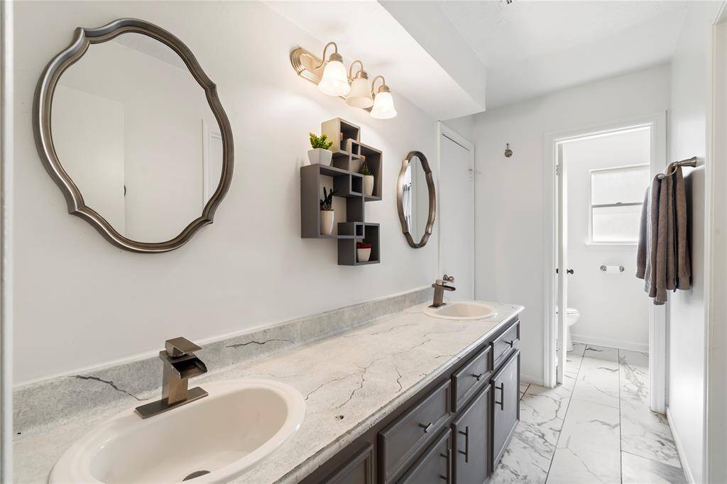 Upstairs bathroom with double vanity, plenty of counter space, and a separate area for the toilet and shower. Functional and easy to share.