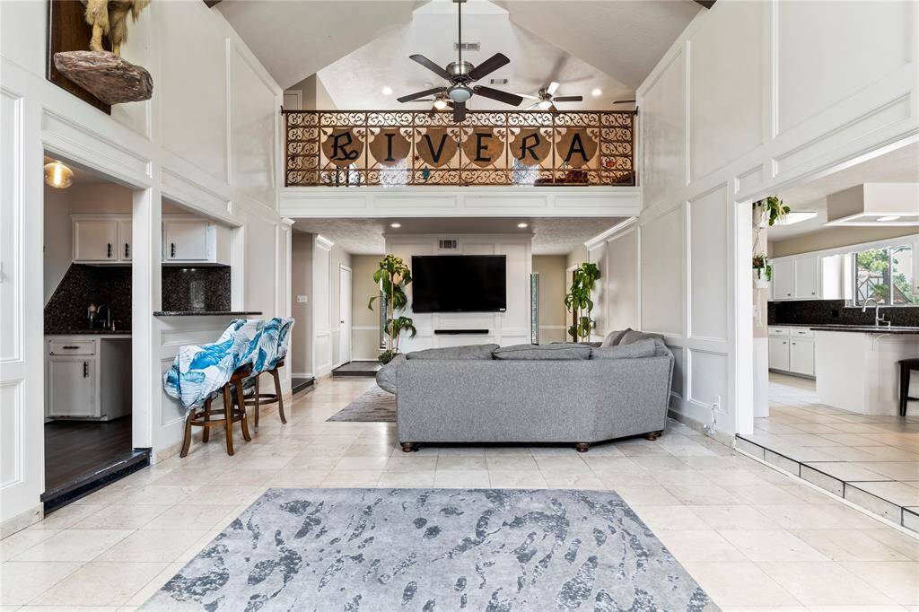 High ceilings and a spacious open layout make this living area the heart of the home—ideal for both relaxing and entertaining, with seamless access to the kitchen and wet bar.