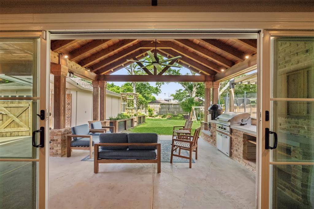 Impressive view of the outdoor living which includes a vaulted ceiling, fully equipped summer kitchen, and separate pergola with fire pit. This creates a seamless entertaining experience, bringing the outdoors in.