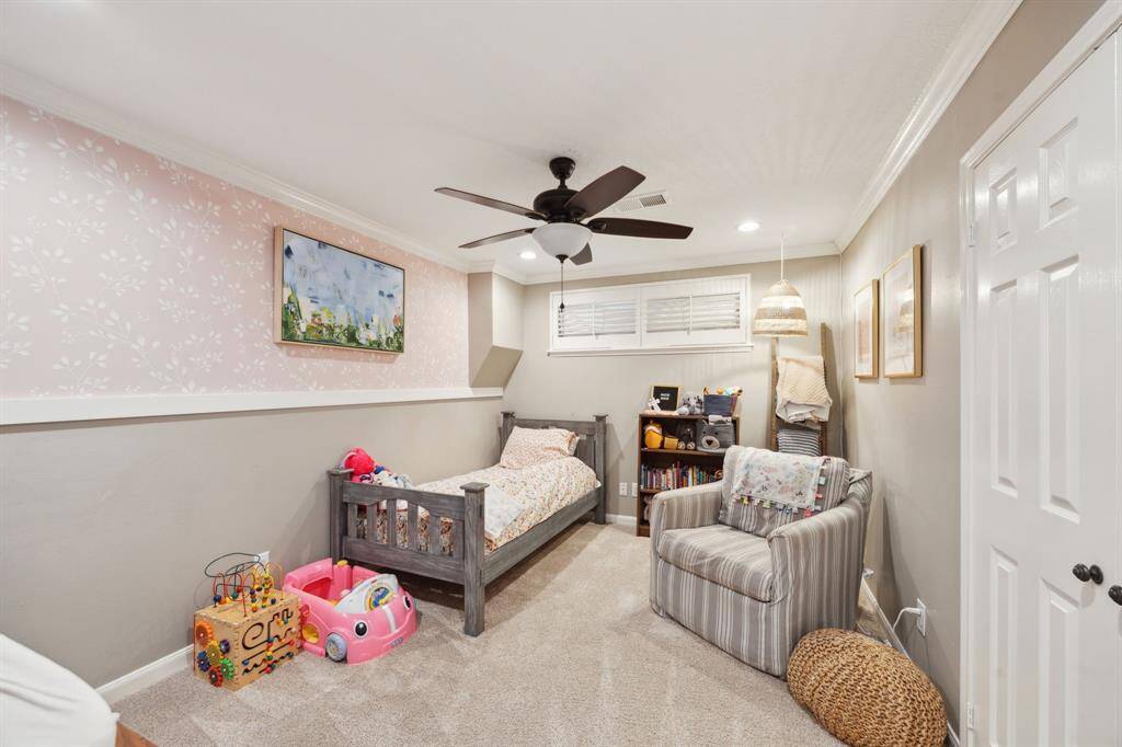 Precious guest bedroom features Plantation shutters and tasteful wallpaper design.