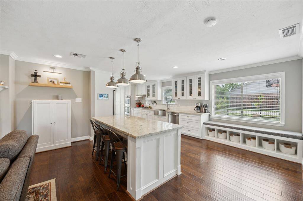 Island kitchen is equipped with stainless steel appliances, double oven, breakfast room, and bar seating.