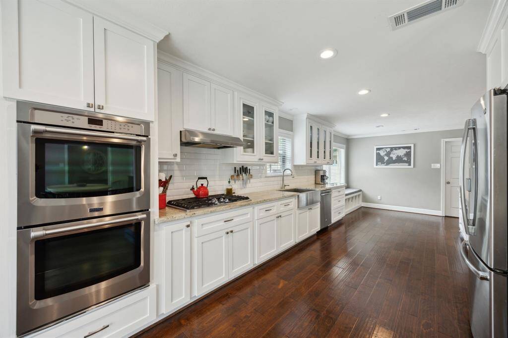 Another view of the kitchen showing the double ovens and gas stove top.