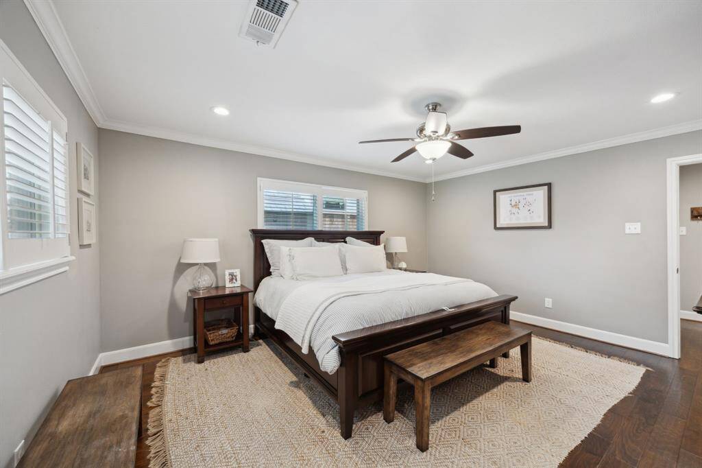 First floor primary suite with engineered hardwoods, Plantation shutters, and a private bath.