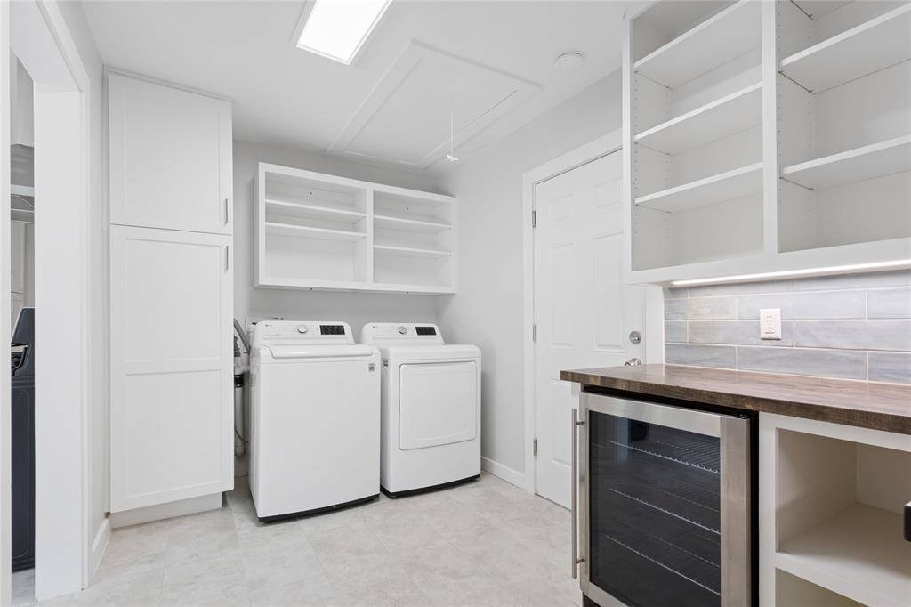 Butler's pantry with wine fridge and laundry in the house.