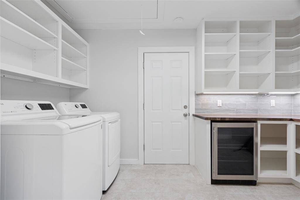 Butler's pantry with wine fridge and laundry in the house.