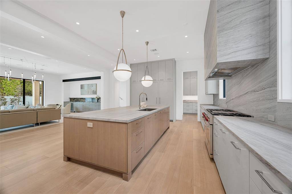 [Gathering Kitchen]This view travels across the kitchen island into the living room.
