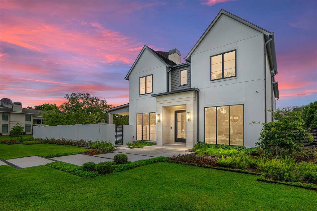 [Front Elevation]This dusk view reveals the large side yard enclosed by a privacy wall.