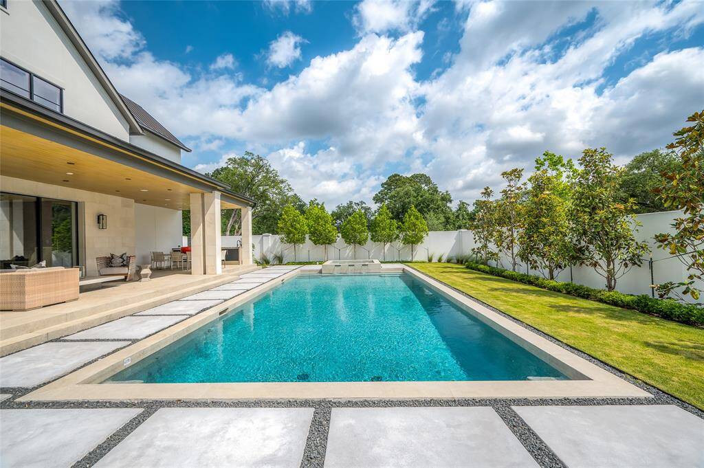[The exceptional swimming pool and spa with water-wall were designed by Sweetwater Pools.