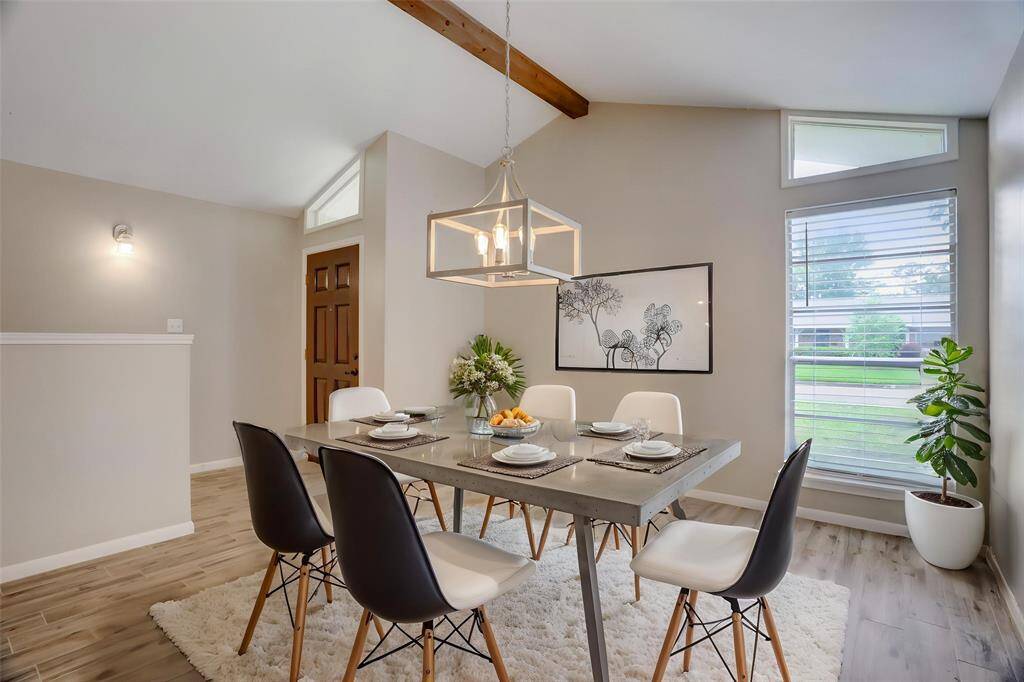 As you step inside you're greeted with a foyer and open views to the gabled-ceiling formal dining room. This is a virtually staged photo of the dining room with great natural light.