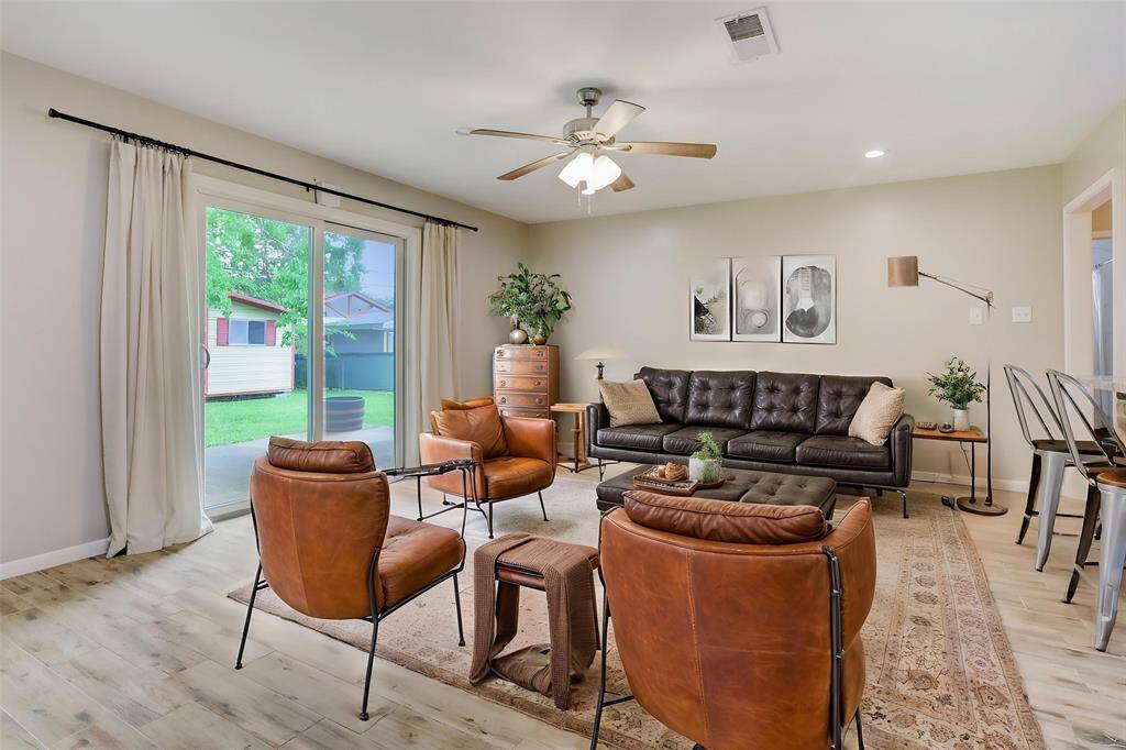 This is a virtually staged photo of the living room including sliding door with access to backyard.