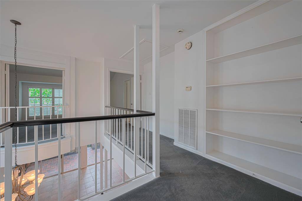 The upstairs hall features a storage closet and built-in bookshelves.