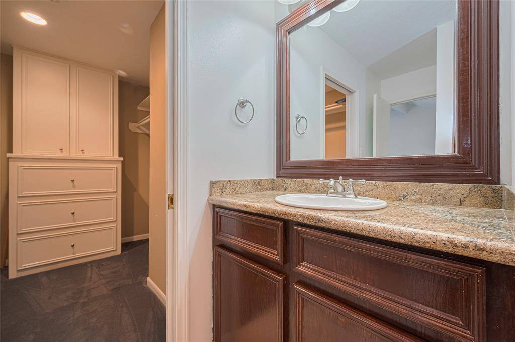 The ensuite bath in the primary has a large walk-in closet with built-in cabinetry.