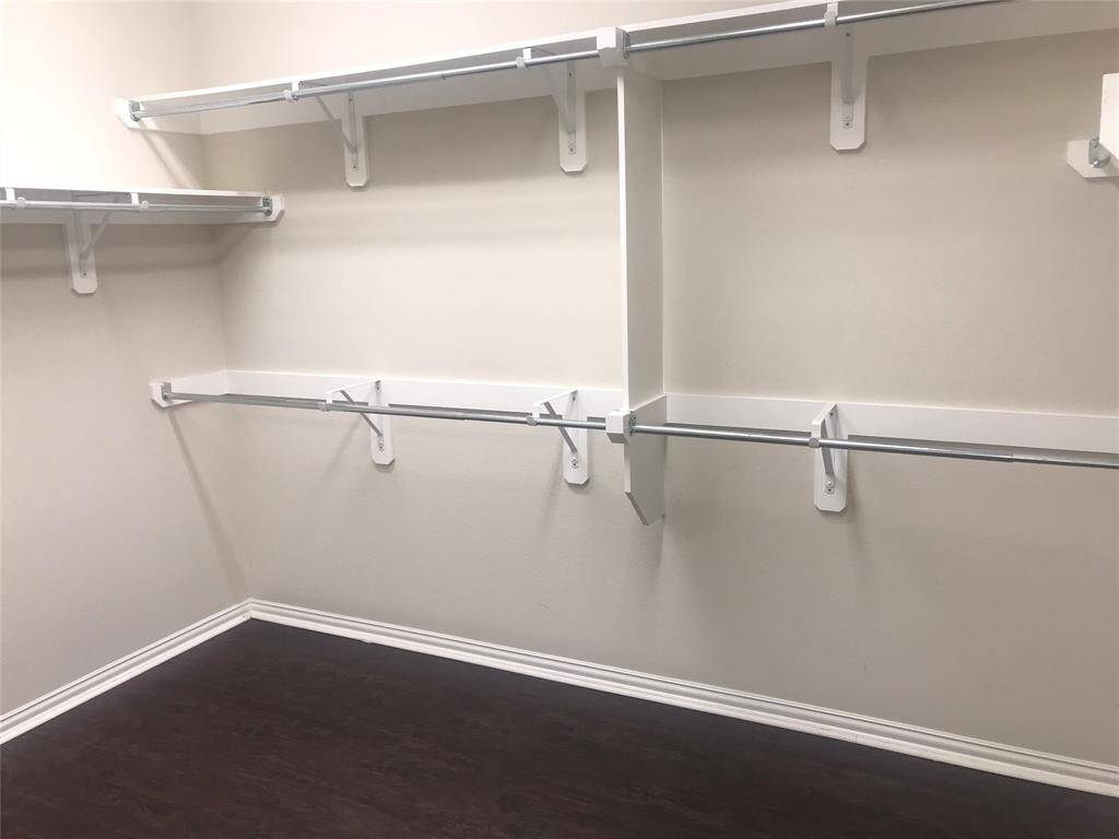 Primary Bedroom Closet with Packed Ironing Board and extra storage room