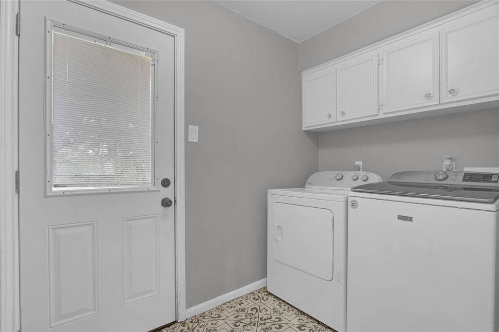 Chic laundry space with stylish tile flooring and ample cabinetry for storage.
