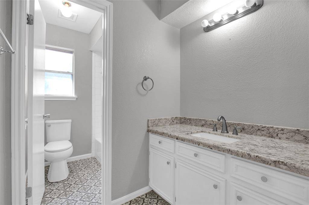 Charming secondary bathroom featuring modern fixtures, natural light, and elegant granite countertops.
