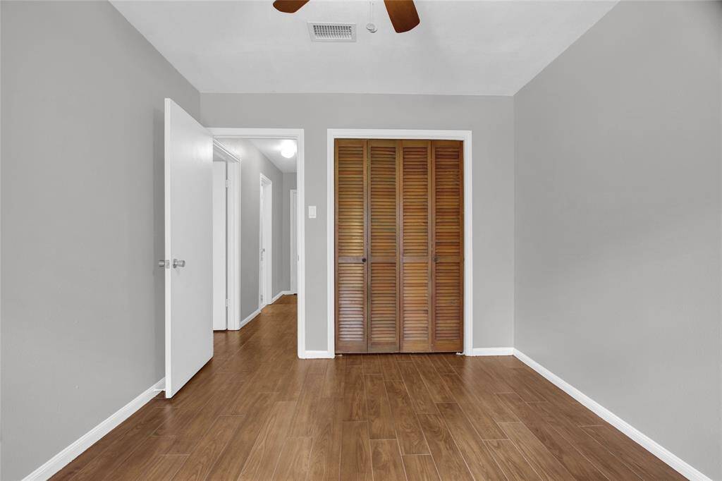 Versatile fourth bedroom with ample natural light and elegant hardwood look tile flooring.