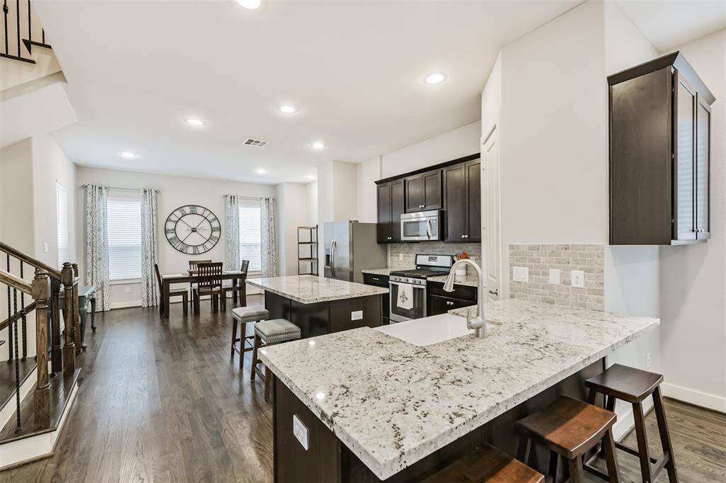 Highlighting the expansive kitchen on the second floor with gleaming light colored granite countertops, real hardwood floors, and light grey walls- this home is both modern and cozy!