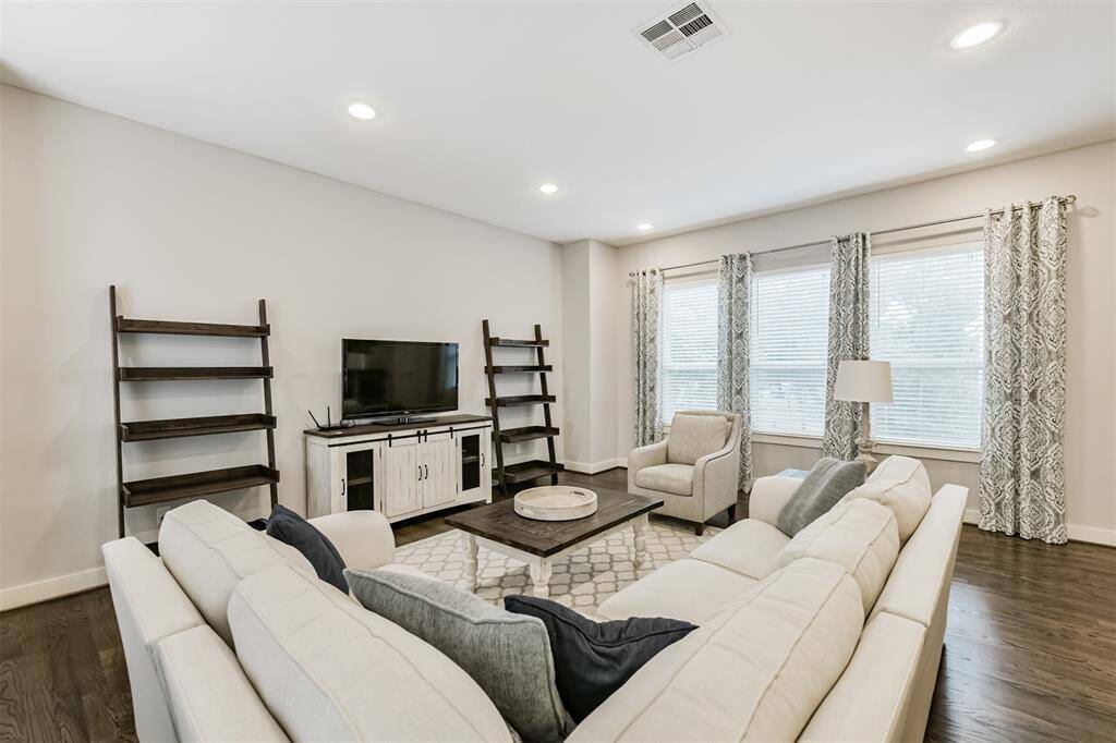 Here is a glimpse of the living room adjacent to the kitchen on the second floor with recessed lighting. Installed window blinds STAY. Home is no longer furnished.