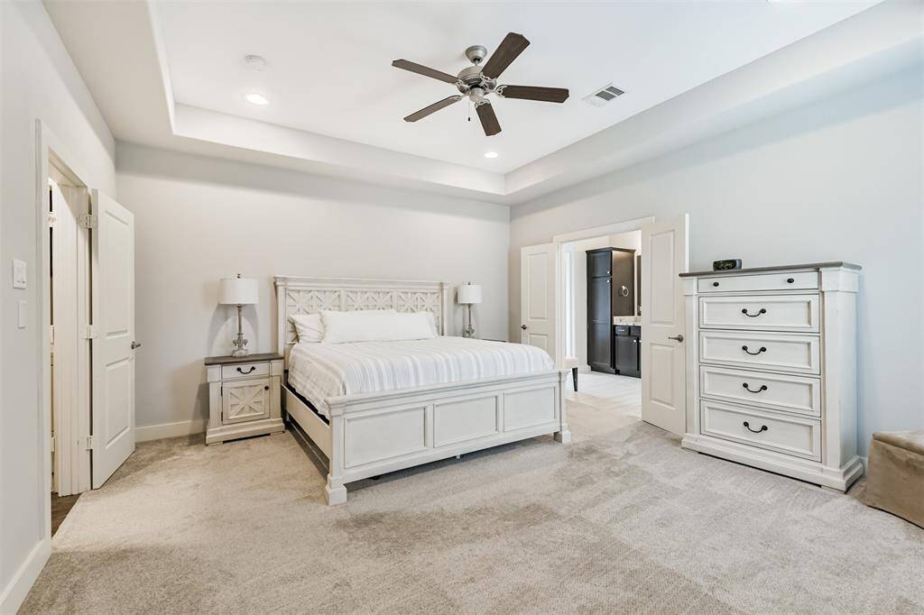 The primary suite sits on the third floor and features a raised ceiling, French doors to the en suite bathroom, and a ceiling fan, of course! At 15x16 feet, there is certainly room for a King bed, side tables, and dressers.
