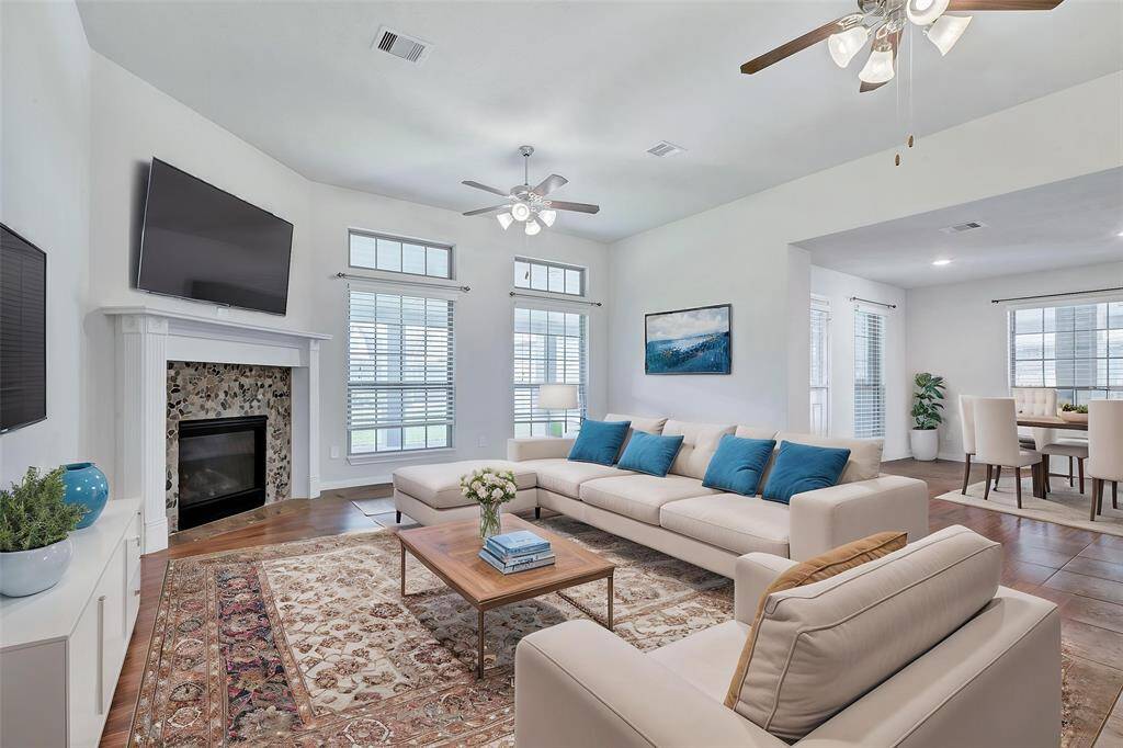 Living room offers beautiful tile flooring, gas log fireplace and view to the backyard. Virtually staged.