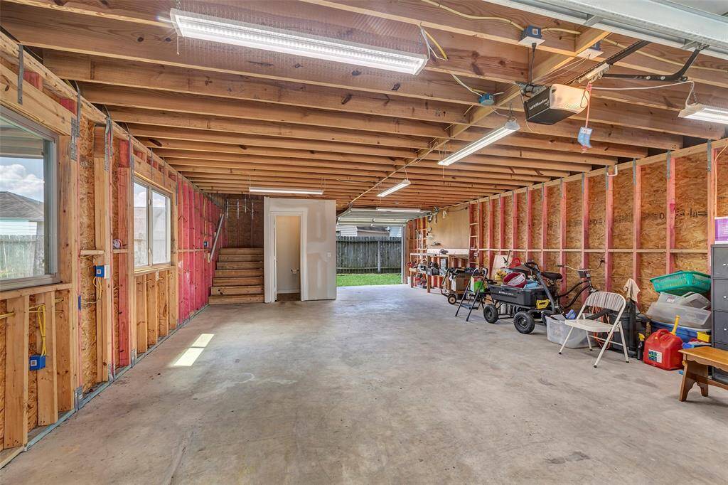 ONE OF A KIND GARAGE! Oversized garage (you can fit 5 Coopers in here!) has a work bench, peg board, half bath, storage under the staircase and 2 GARAGE DOORS (front and back). The stairs are extra wide, 4 feet.