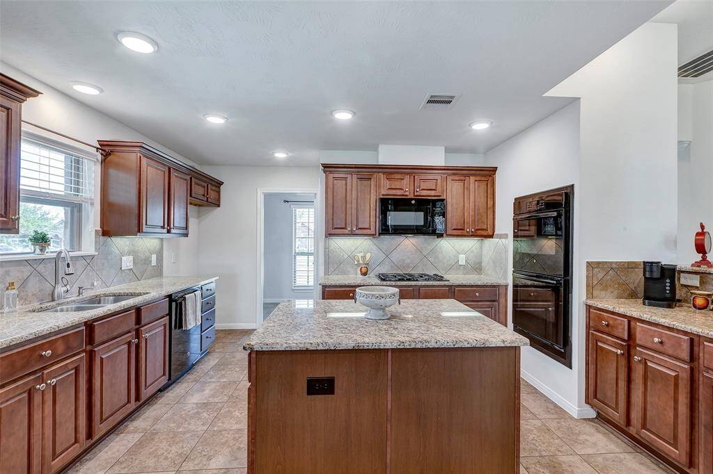 This kitchen has everything you can ask for! Ample cabinet space, large island to prep your food, gas stove and DOUBLE OVEN! It also offers a spacious walk-in pantry.