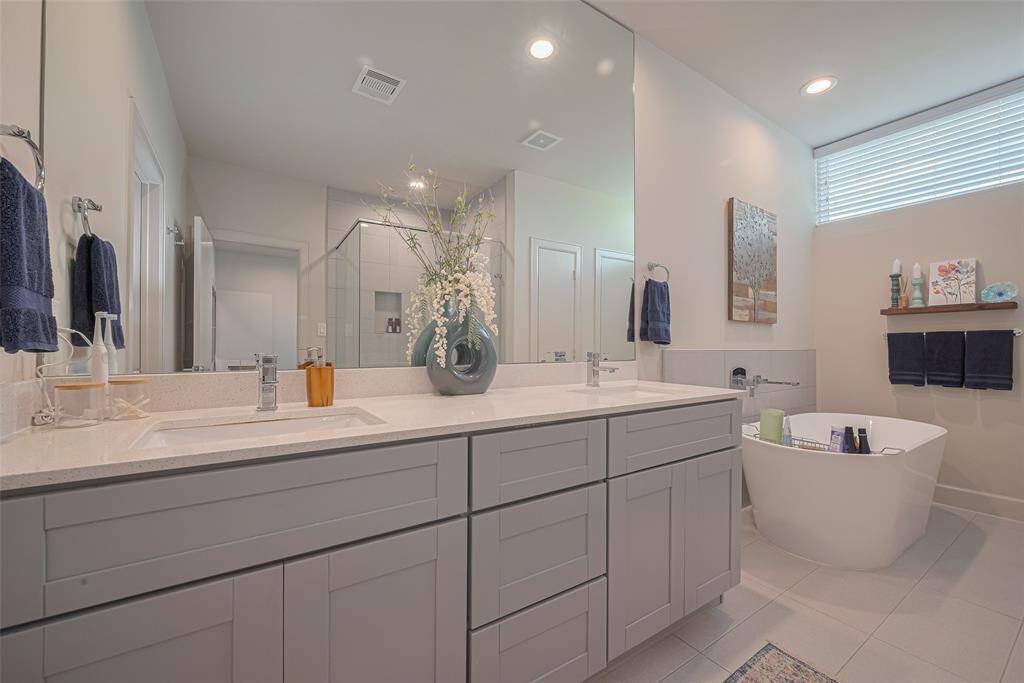 Every detail of the primary bath invites relaxation—from the expansive dual vanity to the elegant soaking tub and generous storage, all bathed in soft natural light and refined finishes.