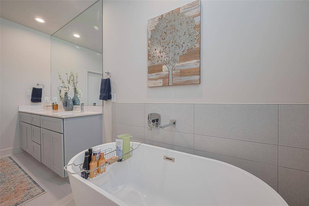 Unwind in elegance—this deep soaking tub, paired with sleek wall tile and spa-inspired finishes, creates a calming oasis in the heart of the primary ensuite.
