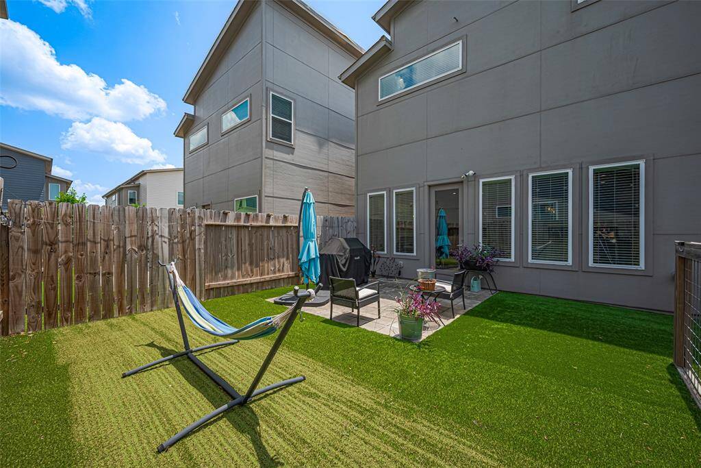 Grill, lounge, or hammock the day away—this beautifully maintained backyard offers turf for easy upkeep, a private patio for entertaining, and seamless access from the main living area.