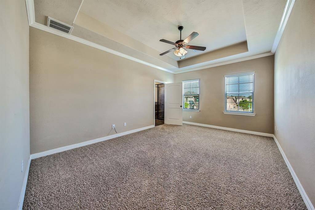 The owner's suite features a tray ceiling, crown molding, and large windows.