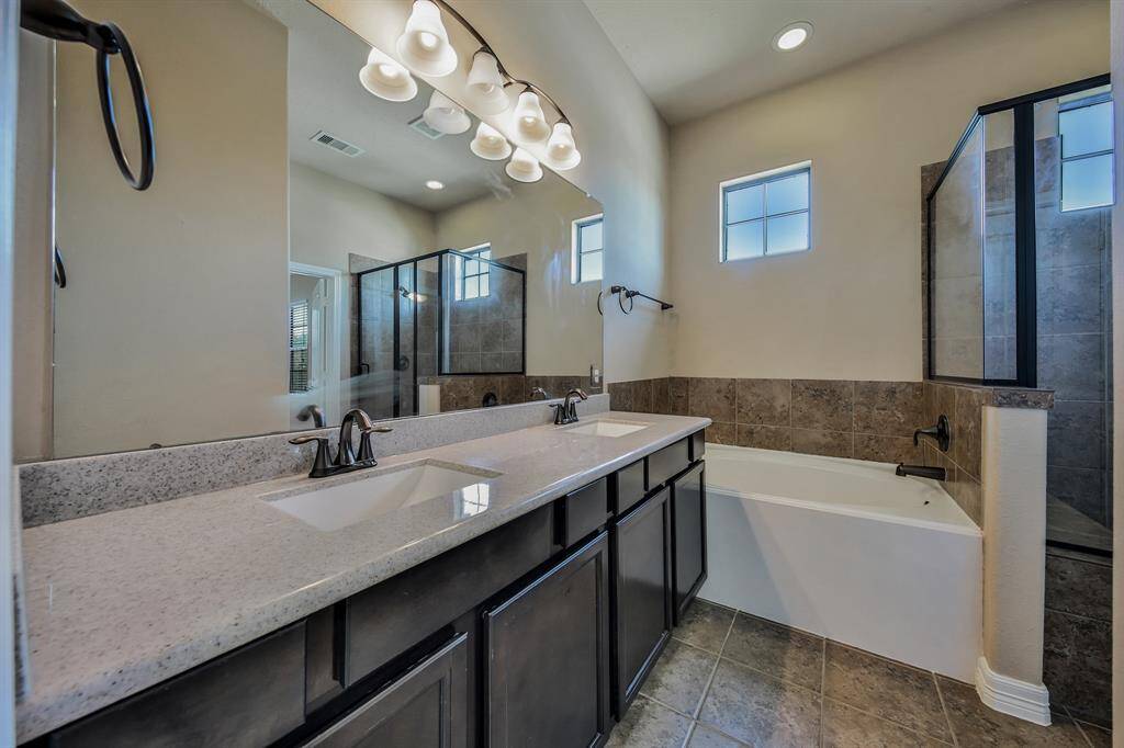 The owner's bath offers dual sinks, a large glass shower, and garden tub.