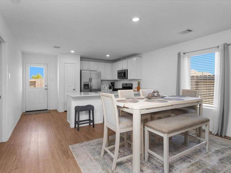 The dining room is bright and airy, featuring a beautiful window that lets in plenty of natural light, along with elegant flooring that adds warmth and charm to the space.