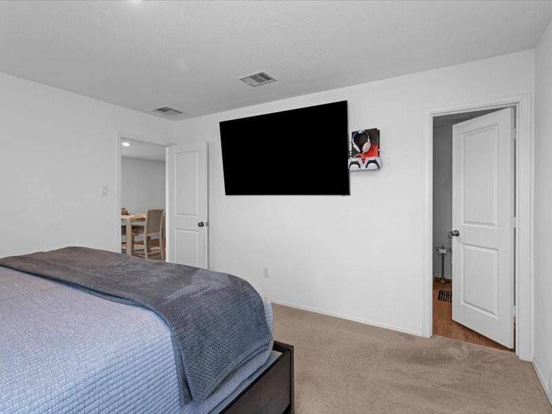 The TV and all furnishings shown in the room are included, making this primary bedroom truly move-in ready.