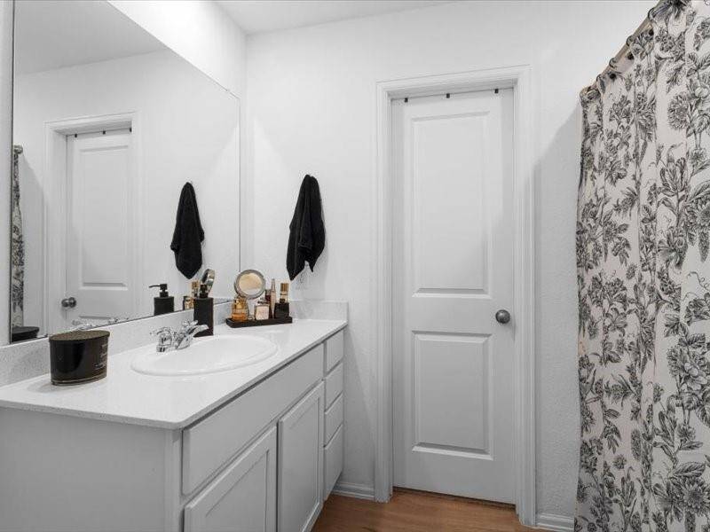 The primary bathroom offers a tranquil retreat with elegant finishes, featuring a spacious vanity, and a separate shower for ultimate convenience and comfort.