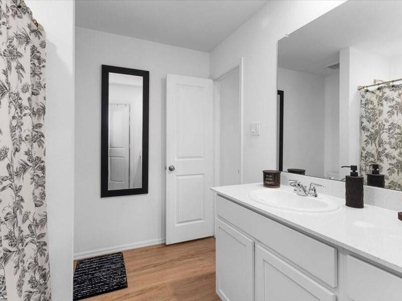 The primary bathroom offers plenty of counter space and ample storage, ensuring everything has its place while maintaining a clean, organized look.