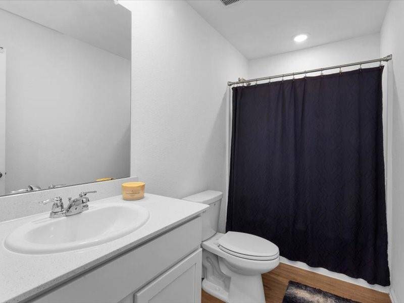 The secondary bathroom features a tub, providing a relaxing space for family or guests. It’s both functional and inviting with tasteful finishes throughout.