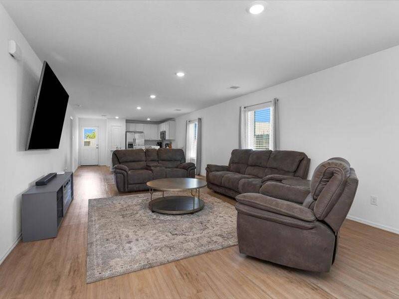 The cozy family room is filled with natural light from large windows, creating a warm and inviting space to unwind.