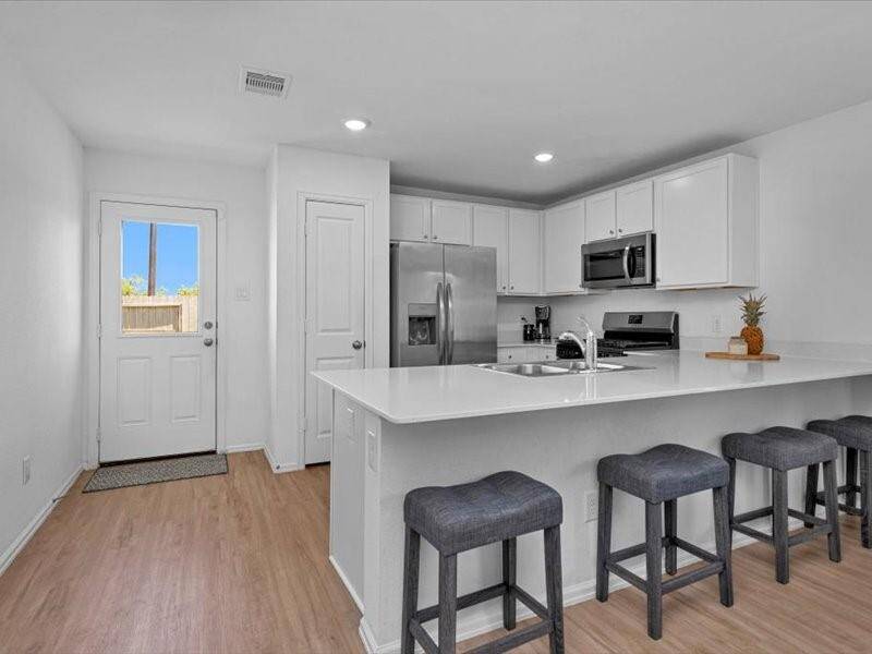 The kitchen also features additional seating at the island, providing a perfect spot for casual meals, conversation, or enjoying your morning coffee.