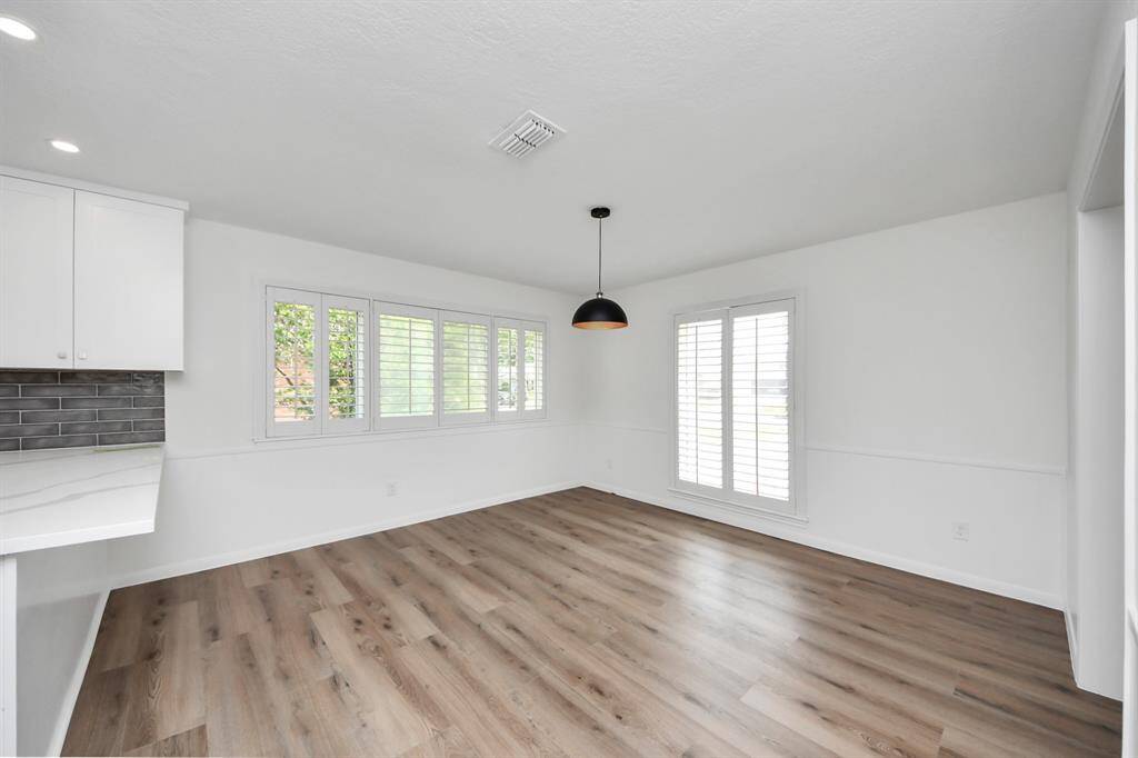 The light-filled breakfast area offers a serene spot to start your day, surrounded by plantation shutters and views of the landscaped front yard. Its open flow to the kitchen makes casual dining both effortless and inviting.
