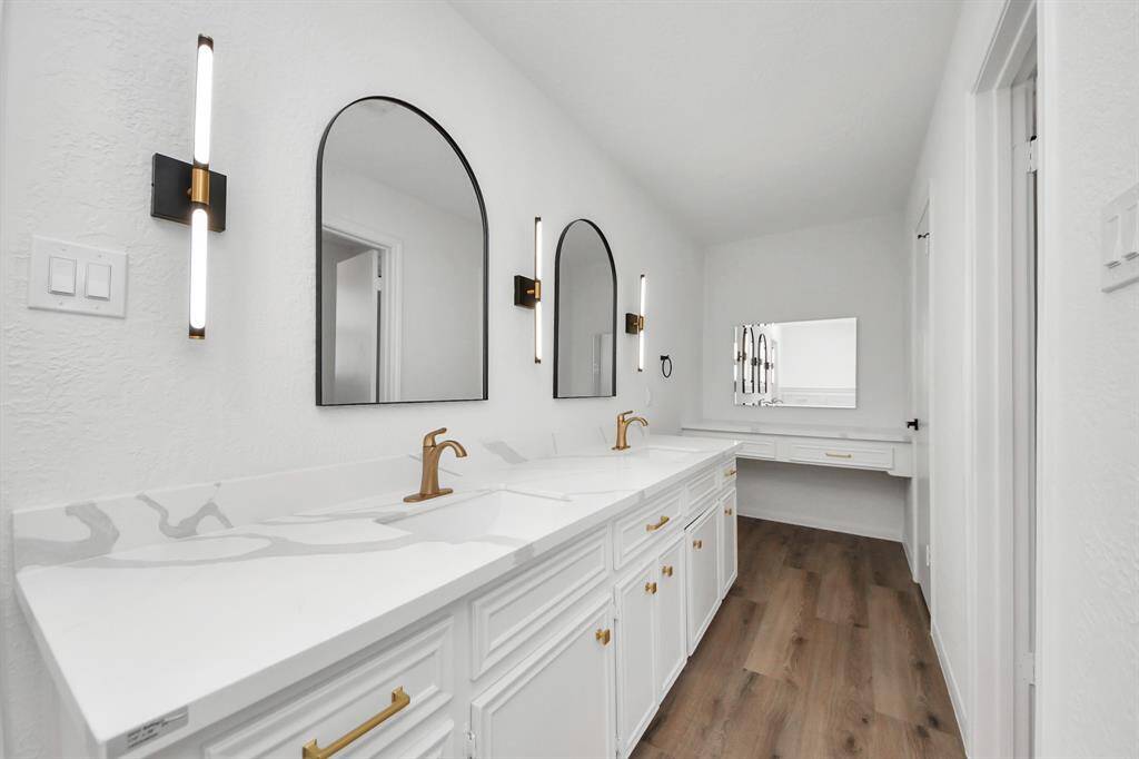 A built-in makeup vanity and elegant gold hardware add both function and flair to this spa-inspired space.